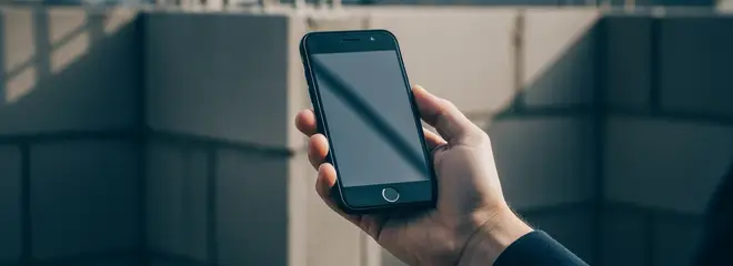 Hand fotografiert eine Baustelle mit dem Handy